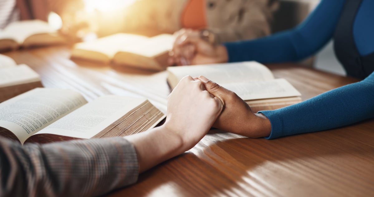 Hand holding, Bible and people with prayer for religion, guidance or support with scripture for worship.